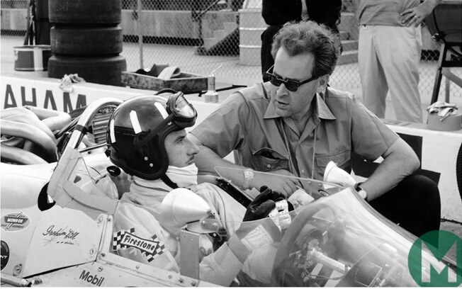 Lola founder Eric Broadley speaking with Formula 1 champion Graham Hill